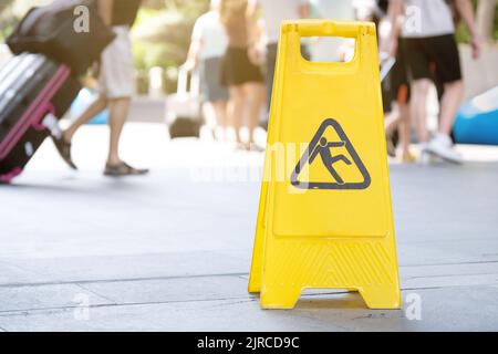 Yellow caution wet floor sign stands in airport Stock Photo