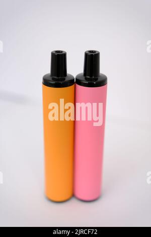 pink and orange disposable electronic cigarettes on white background. Copy space. Stock Photo