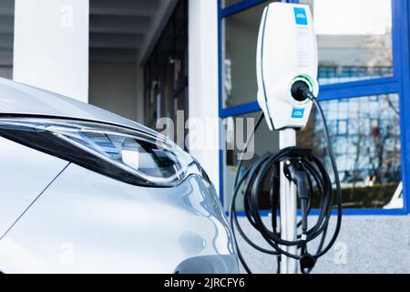 Close up of electric car next to charging station Stock Photo