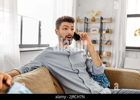 man calling on smartphone at home Stock Photo