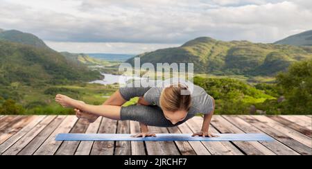 woman doing yoga over Killarney National Park Stock Photo