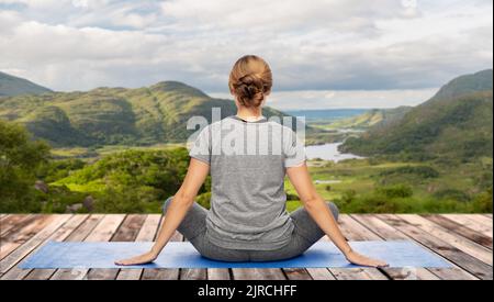 woman doing yoga over Killarney National Park Stock Photo