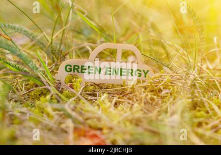 Ecology and transportation concept. There is a wooden car in the grass that says - green energy Stock Photo