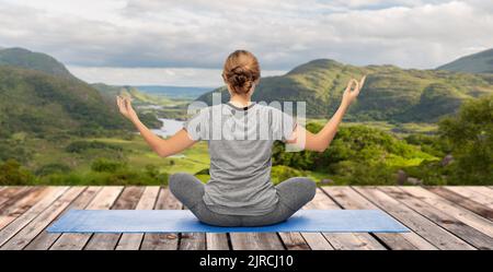 woman doing yoga over Killarney National Park Stock Photo