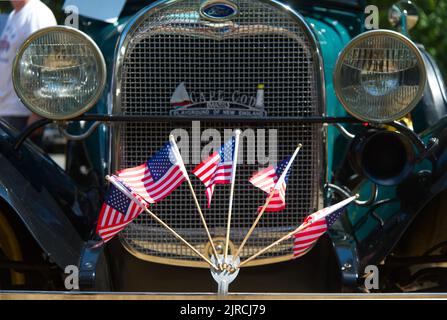 US Flags fly on the front bumper of a restored antique Ford in an antique auto parade in Dennis, Massachusetts, Cape Cod, USA Stock Photo