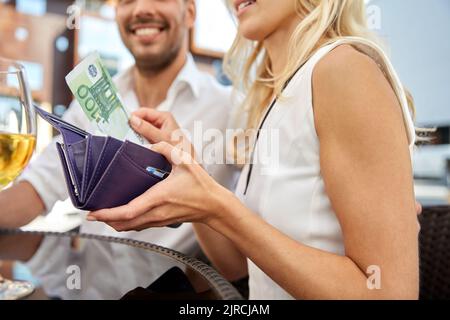 close up of couple with money paying at restaurant Stock Photo