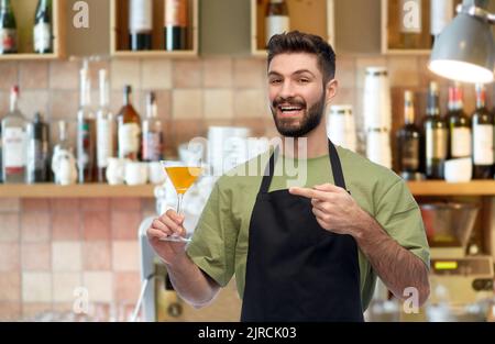 barman in apron with glass of cocktail at bar Stock Photo