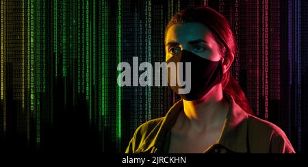 female hacker in black mask over binary code Stock Photo