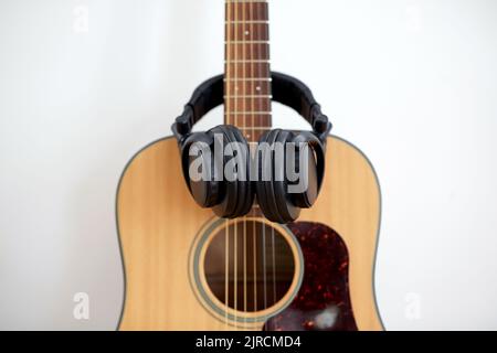 close up of acoustic guitar and headphones Stock Photo