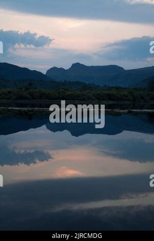 Langdale Pikes reflected in Elter Water Lake at sunset in the English Lake District Stock Photo