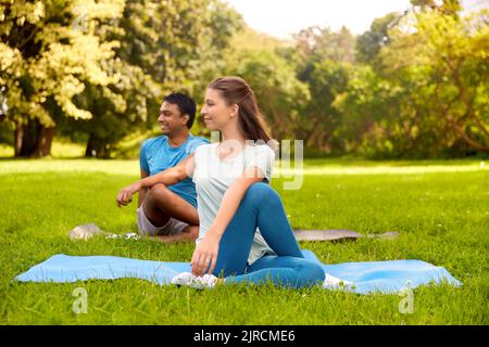happy people doing yoga at summer park Stock Photo