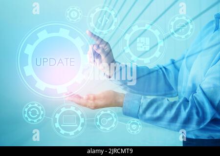 Businesswoman using virtual screen with word UPDATE on blue background Stock Photo