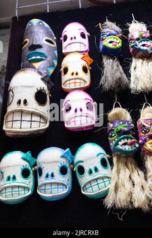 colorful mexican tiki style day of the dead bearded skull mask of carnival of oaxaca adornment for sale in a traditional market as souvenir for touris Stock Photo