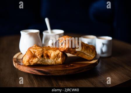 Pastries and coffee on coffee table in living room Stock Photo