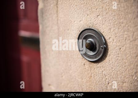 Antique brass doorbell with green patina outside front door. Stock Photo