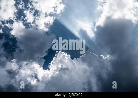 Dramatic shot of sun breaking through  stratocumulus clouds Stock Photo