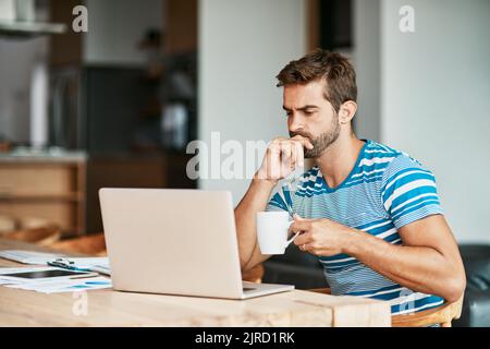 Hes got a lot to think about it. a handsome young male entrepreneur looking thoughtful while working from his home office. Stock Photo