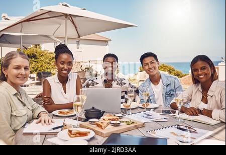 Collaboration, food and meeting with a team eating and working at a restaurant for a client lunch. Teamwork, solidarity and diversity with a group of Stock Photo