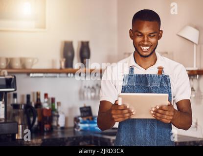 Management, planning and stock with happy restaurant manager checking inventory on digital tablet. Proud employee feeling successful while doing Stock Photo