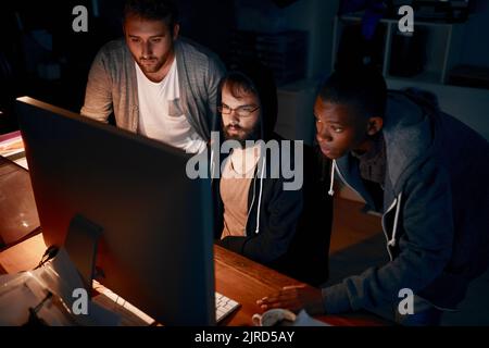 Focused on the code. young computer programmers working late in the office. Stock Photo