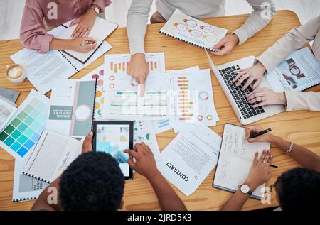 Meeting, planning and finance with a group or team of business people discussing data, a contract or financial report from above. Overhead of a Stock Photo