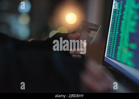 Its easier than you think for thieves to attack. an unrecognisable hacker using a laptop to hack into a credit account. Stock Photo