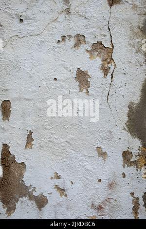 old white-painted wall deteriorated by the weather Stock Photo