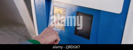 Woman hand typing pin code on ATM keyboard closeup Stock Photo