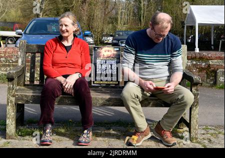 2 people sitting on a bench during COVID-19 lockdown, Chawton, Hampshire, UK. Stock Photo
