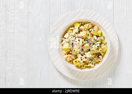 shout hallelujah potato salad with pickles, celery, eggs, jalapeno and mayonnaise dressing in white bowl on wooden table, american cuisine, horizontal Stock Photo