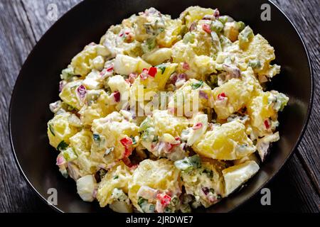 close-up of shout hallelujah potato salad with pickles, celery, eggs, jalapeno and mayonnaise dressing in black bowl, american cuisine Stock Photo