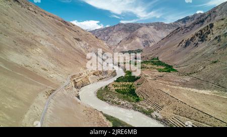 aerial landscape of mountain road through Spiti Valley in Himachal Pradesh with river on sunny day Stock Photo