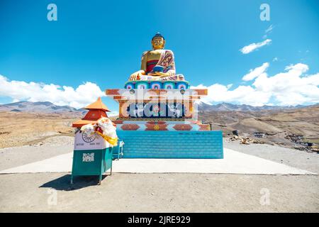 colorful and vibrant golden buddha statue in Langza Village surrounded by Himalayan Mountains in Spiti Valley Stock Photo