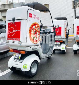 A rear picture of Three 3 Wheel Mobility Scooter Balance Delivery Motorcycles for pizza Salvatore with Roofs parked in a parking lot. Stock Photo