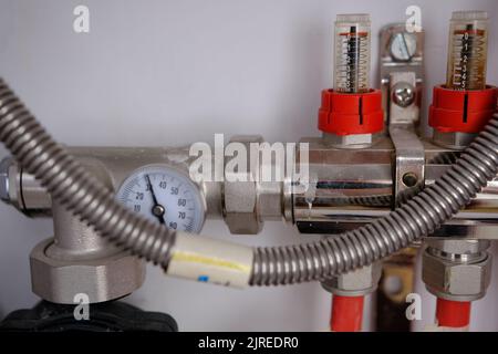 Heating system manifold valves for heat flooring and water supply in a country house. Pipes collector in a building under construction. Stock Photo
