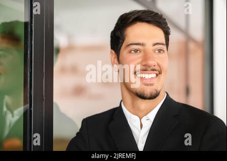 Close-up headshot portrait of successful masculine latin businessman in formal expensive suit indoors, smiling proud male entrepreneur, ceo, manager Stock Photo