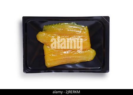 Overhead shot of smoked Vietnamese Basa fish in black vacuum packaging, isolated on white background with clipping path Stock Photo