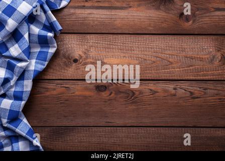 Old vintage planked wood board with blue checkered table cloth, background with space for text Stock Photo