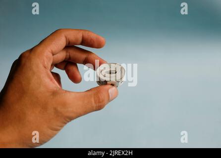 Close up hand holding measuring tape isolated on blue background Stock Photo