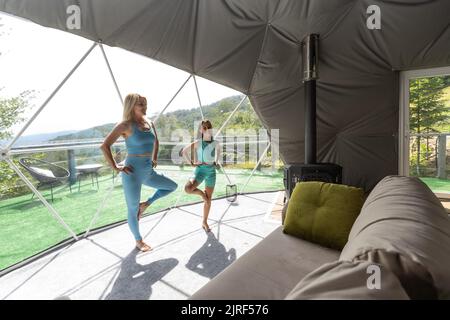 mother and daughter yoga in a glamping dome tent Stock Photo - Alamy