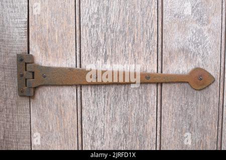 Rusty door hinge on a wooden door Stock Photo
