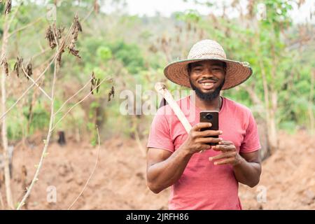 african farmer checking his phone Stock Photo