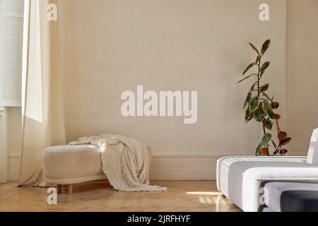 Interior of classy living room with soft couch and bench in sunlight Stock Photo