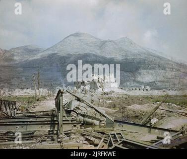 The ruins of Cassino, May 1944: a wrecked Sherman tank and Bailey bridge in the foreground, with Monastery Ridge and Castle Hill in the background. View of Cassino after heavy bombardment showing a knocked out Sherman tank by a Bailey bridge in the foreground with Monastery Ridge and Castle Hill in the background. Stock Photo