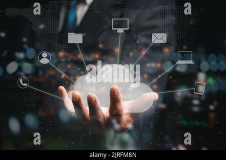 A businessman hold a cloud storage icon on his hand with different technology-related icons Stock Photo