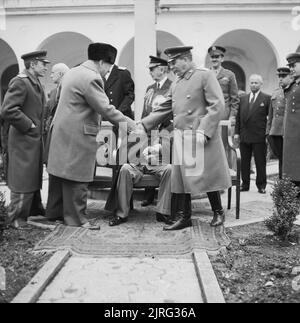 Winston Churchill greets Joseph Stalin with President Roosevelt outside the Livadia Palace during the Yalta Conference, February 1945. Winston Churchill (standing left) shakes hand with Joseph Stalin (standing right) outside the Livadia Palace during the Yalta Conference. President Roosevelt is seated between them. Just visible between Churchill and Stalin is Admiral William D Leahy, Chief of Staff to Roosevelt. Stock Photo