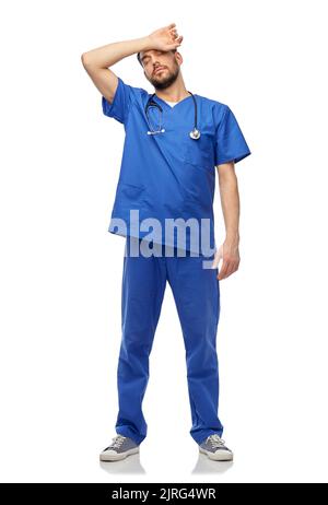 tired doctor or male nurse with stethoscope Stock Photo