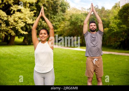 happy people doing yoga at summer park Stock Photo