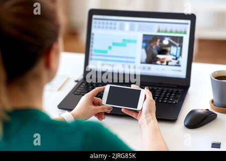 woman smartphone and laptop working at home Stock Photo