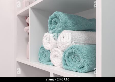 folded towels in the shelf, close up, white and blue Stock Photo